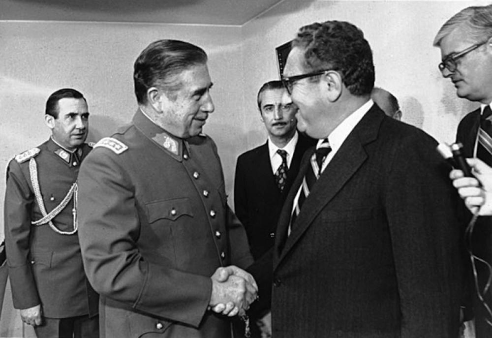 Chilean President Augusto Pinochet shaking hands with Kissinger in 1976. Photo courtesy: Wikipedia/Creative Commons