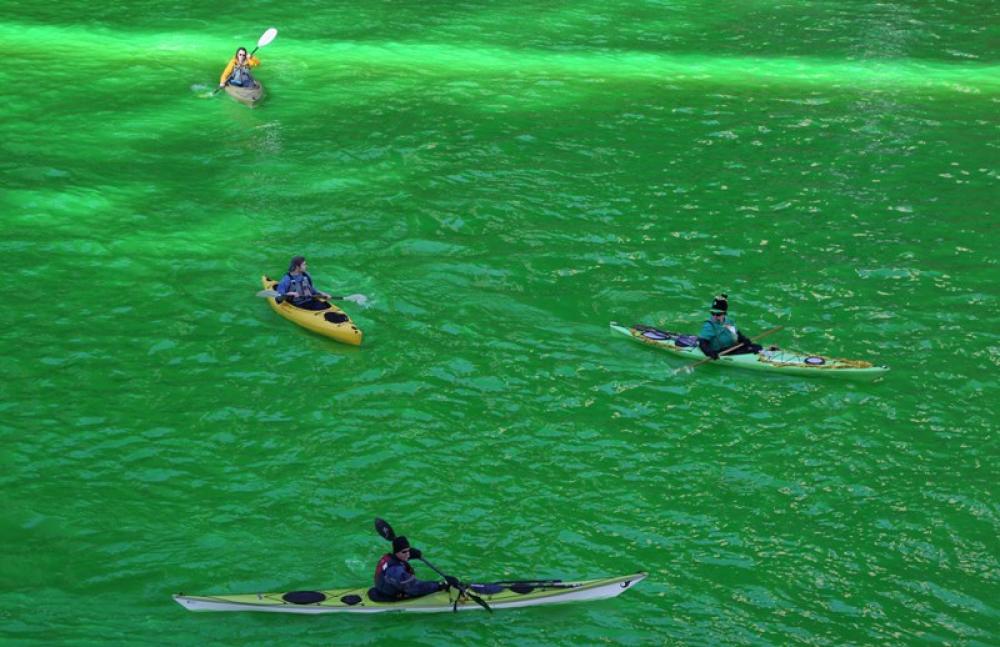 People kayak on the green Chicago River to celebrate St. Patricks Day