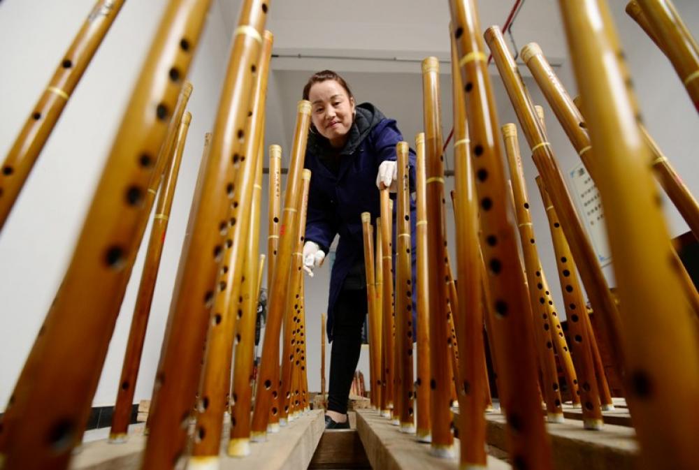 China: Artisan checks Yuping bamboo flutes at workshop in Yuping Dong Autonomous County